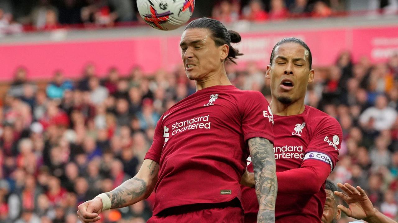 Liverpool forward Darwin Nunez beats teammate Virgil van Dijk in the air to header the ball clear